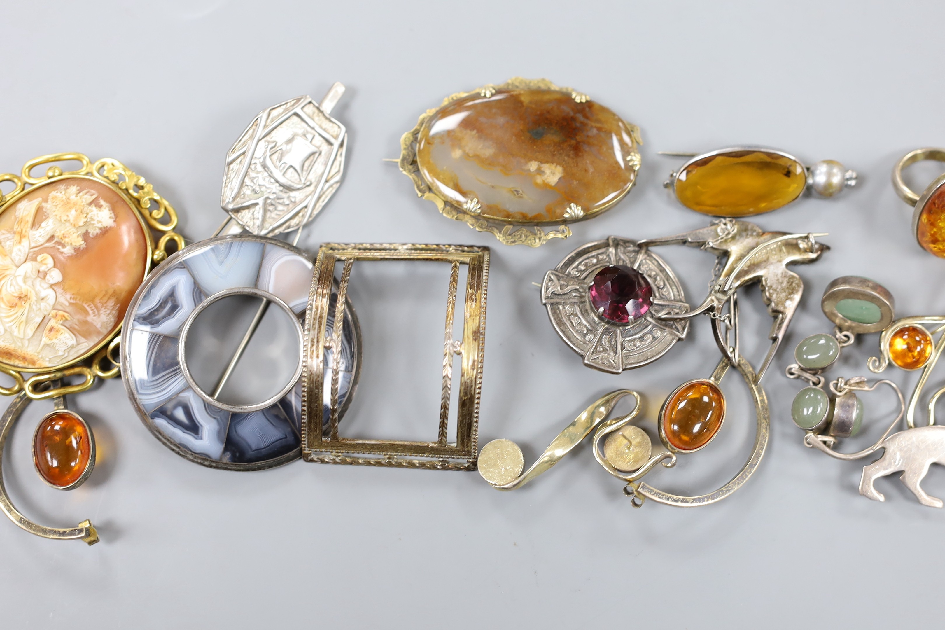 A mixed group of jewellery including a Victorian yellow metal and gem set oval brooch, a filigree white metal and enamel peacock brooch, a white metal and paste set swallow brooch, Scottish hardstone set brooch, pinchbec